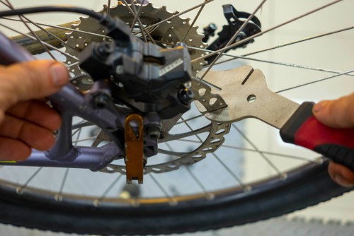 rotor truing fork being used on bent disc brake
